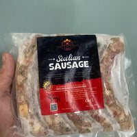 Packaged Stelian Sausage held by a hand on a light gray background