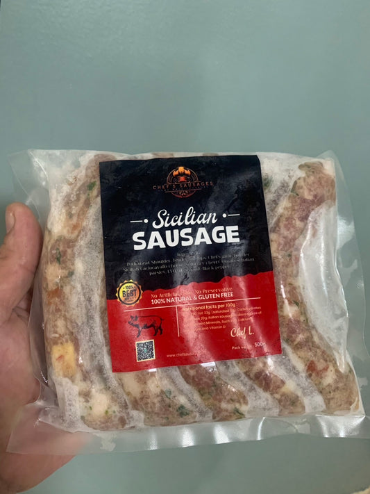 Packaged Stelian Sausage held by a hand on a light gray background